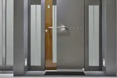 9 modelos de puertas de acero inoxidable que lucirán espectaculares en tu casa 1 Puerta de acero inoxidable en la entrada de una casa de estilo moderno