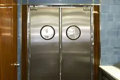 9 modelos de puertas de acero inoxidable que lucirán espectaculares en tu casa 8 Puerta doble de acero inoxidable colocada al fondo de una cocina industrial