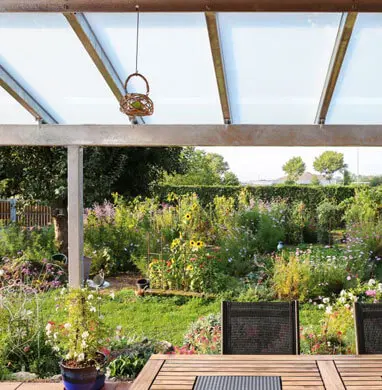 ¡Aprende a construir pérgolas de acero inoxidable de una forma sencilla! 12 Pérgola de metal colocada frente al jardín de una casa