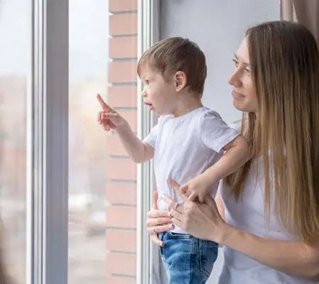 Perfiles de aluminio para ventanas: Usos y ventajas. ¡Descubre consejos para una fácil instalación! 4 Mujer y niño observando al exterior de una ventana fija hecha con perfiles de aluminio
