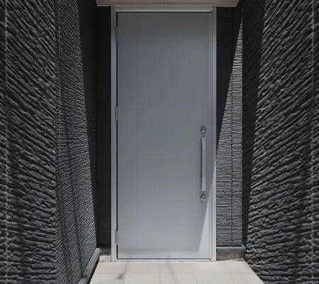Puertas de Aluminio ¡La mejor opción para el hogar! 4 Vista frontal de una puerta para recámara color gris metálico con acabados, la habitación en donde se encuentra tiene acabados grises con una entrada de luz a la derecha