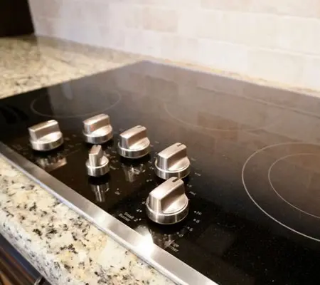 Pasos para limpiar Estufa de Acero Inoxidable 3 Plano cercano de la superficie de una estufa de acero inoxidable eléctrica con cinco resistencias para cocinar