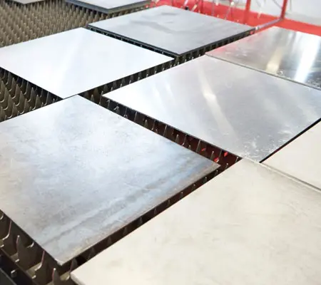 Tipos de láminas de Acero Inoxidable ideales para tu proyecto 1 Algunas láminas sobre una mesa de corte laser