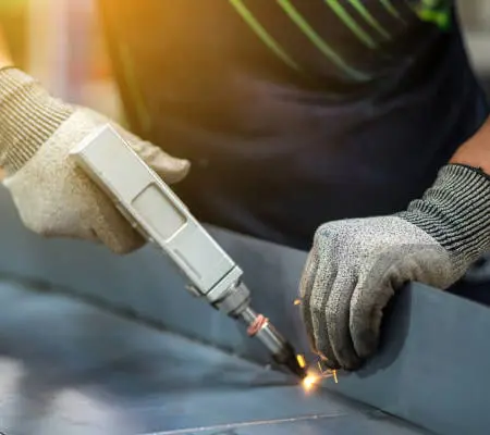 Soldadura de aluminio: Descubre 8 Técnicas para hacerlo efectivamente 7 Manos de trabajador realizando unión de piezas con láser - Soldadura de aluminio