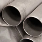 piezas de tubos de acero inoxidable apiladas en un almacen